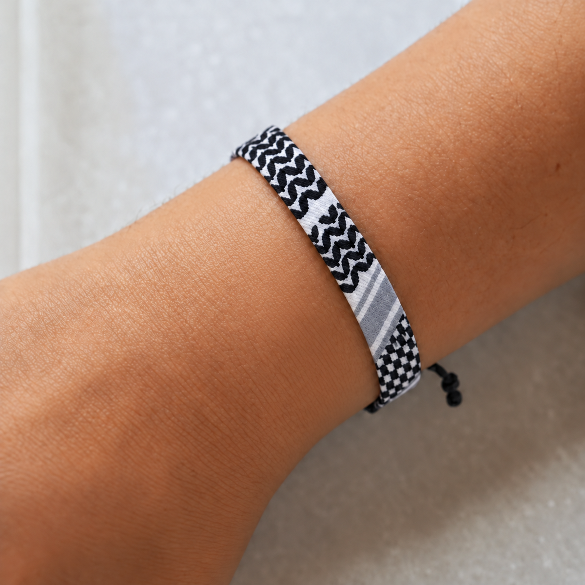 Black and white keffiyeh pattern bracelet worn on a wrist