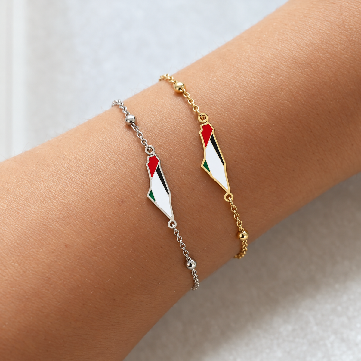 Gold- and silver-plated Palestine map bracelets worn on a wrist